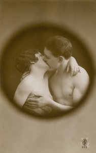 Young man and woman kissing as viewed through a peephole